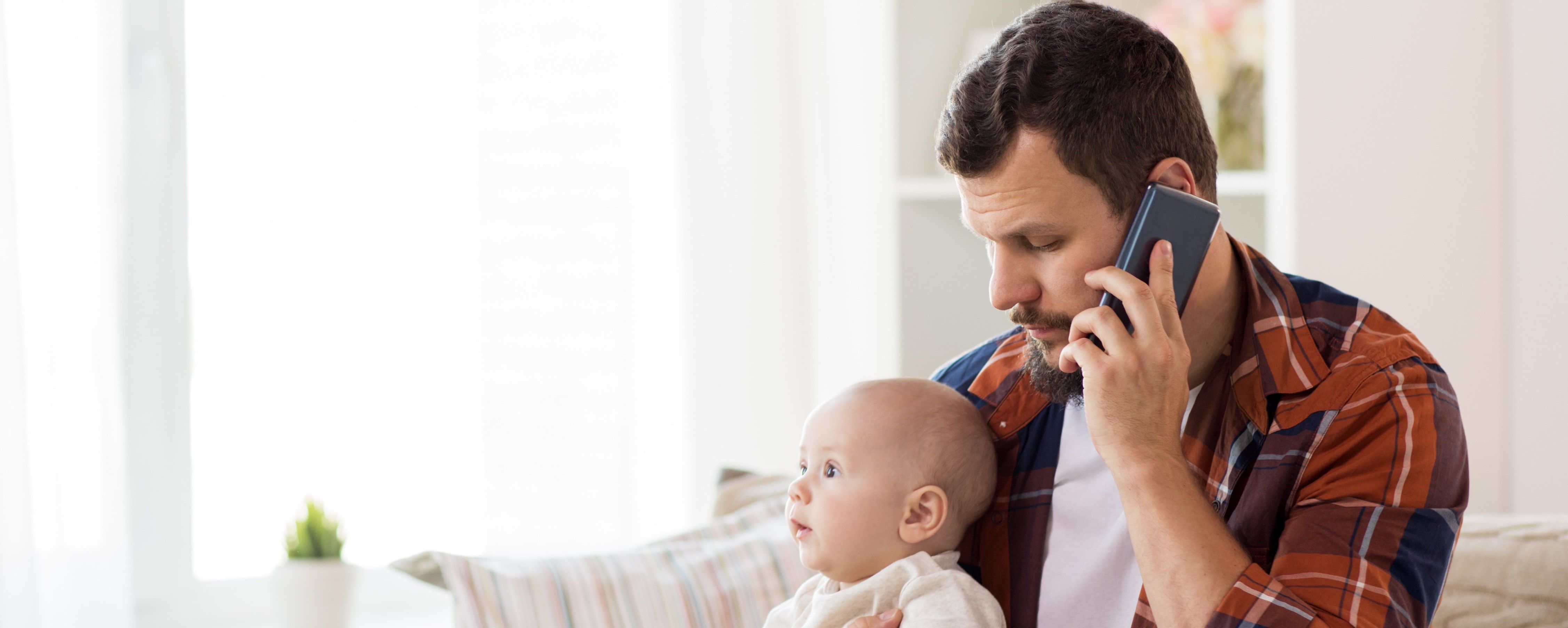 Father with baby making a telephone call.